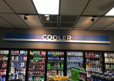 Interior sign for a convenience store that reads "Cooler". The sign is placed above a drink cool.