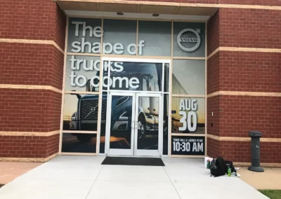 Text reads "The Shape of Trucks to Come". Background is a sunset photograph of a Volvo 18-wheeler truck. Other text reads "August 30" and "Town Hall & Launch Picnic 10:30am"