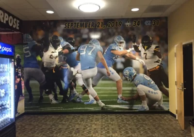 A large wall print of a football game from September 21, 2019 between App State and NC State.