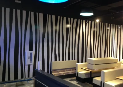 Large wall print with a black and white zebra stripe pattern running vertically from floor to ceiling.