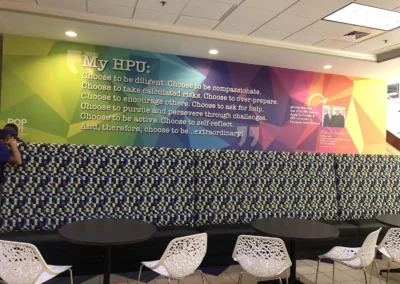 Large colorful wall mural in a cafeteria setting. Text reads "My HPU: Choose to be diligent. Choose to be compassionate. Choose to take calculated risks. Choose to over-prepare. Choose to encourage others. Choose to ask for help. Choose to pursue and persevere through challenges. Choose to be active. Choose to self-reflect. And, therefore, choose to be...extraordinary!"