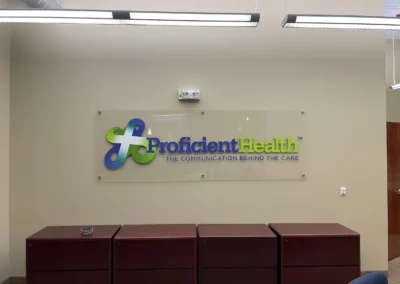 Wall logo printed on glass and mounted. Branding reads "Proficient Health the communication behind the care"